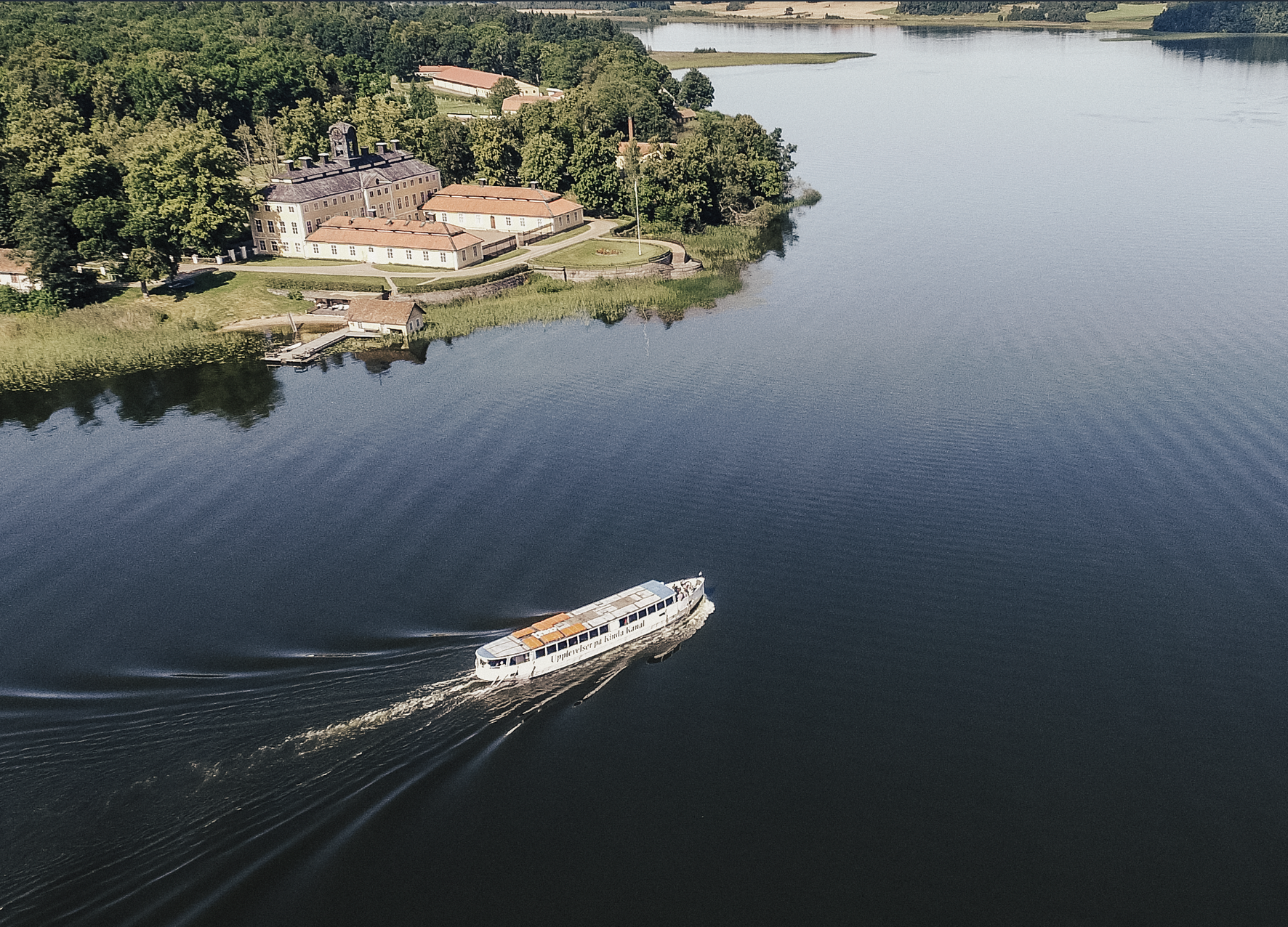 Båten M/S Kind passerar Sturefors slott en solig sommardag