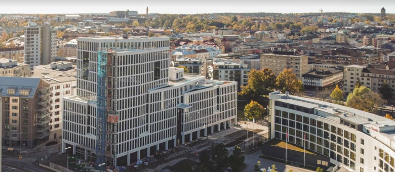 Byggnader i förgrunden och vy över Linköpings innerstad i bakgrunden