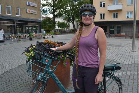 Kvinna med cykel på ett torg