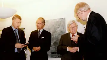 På bilden får de båda kung Carl XVI Gustaf och Sloveninens president Milan Kucan instruktioner hur de ska kunna prata med varandra med hjälp av Sectras avlyssningssäkra telefon Tiger.